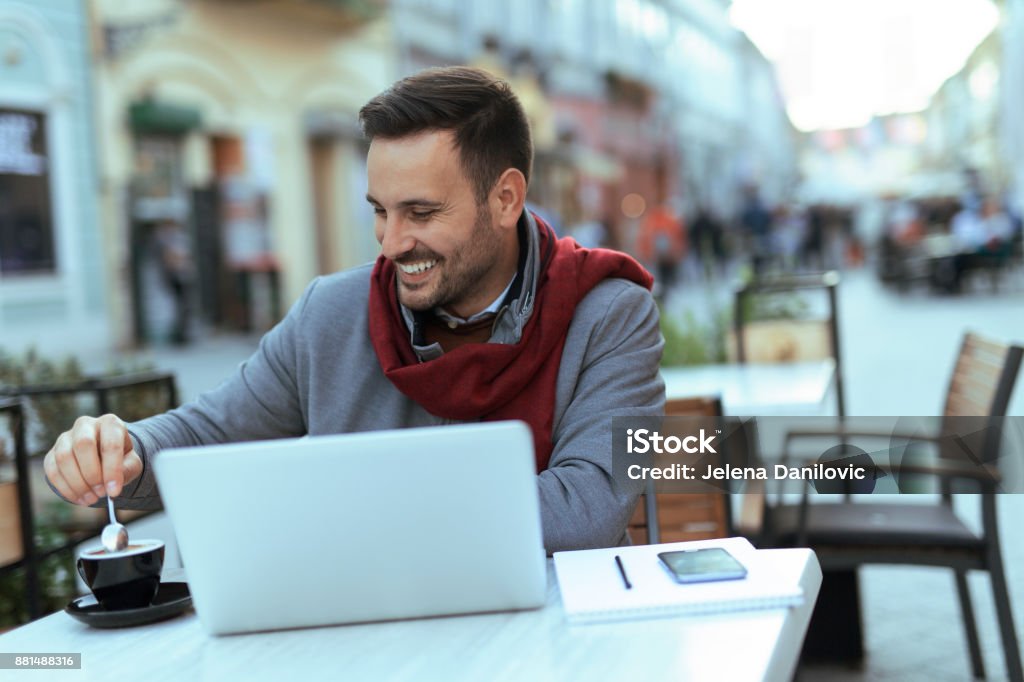 Man at coffeehouse Smiling handsome man taking cup of coffee at coffeehouse Adult Stock Photo