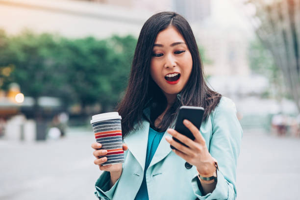 istock Young woman looking at her phone in amazement 881497232