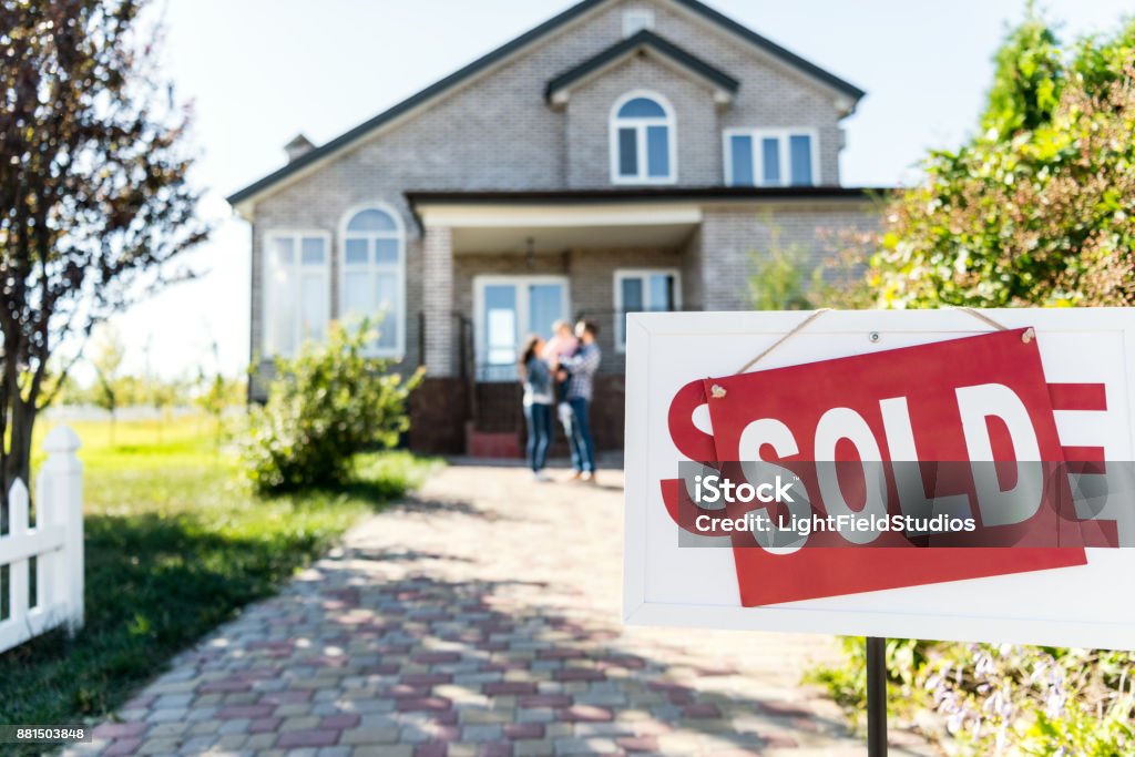 sold house sold house with blurred family on background Selling Stock Photo