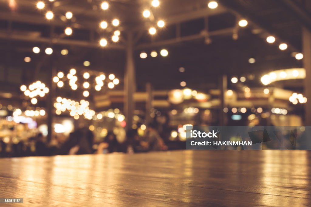 Mesa de madera con desenfoque de iluminación en café de noche - Foto de stock de Barra - Bar libre de derechos