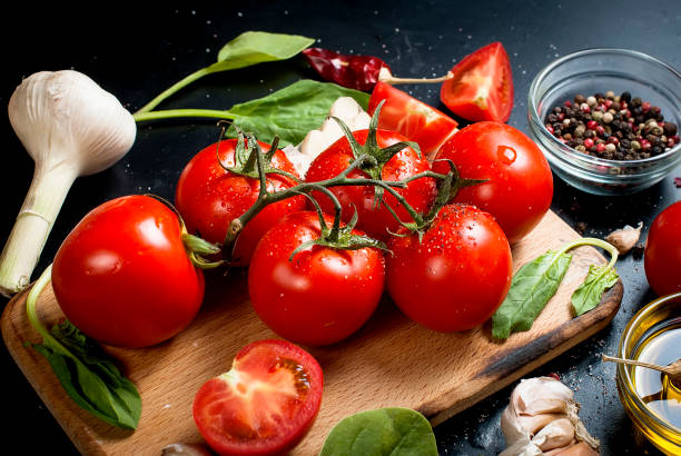 istock Black rustic tabletop with branch of tomatoes and herbs, top view 881511642