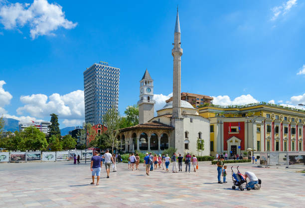Group of tourists on Skanderbeg Square. Efem Bay Mosque, Clock Tower, Plaza Hotel, Tirana, Albania Tirana, Albania - September 6, 2017: Group of unknown tourists on Skanderbeg Square. Efem Bay Mosque, Clock Tower, Plaza Hotel, Tirana, Albania tirana photos stock pictures, royalty-free photos & images