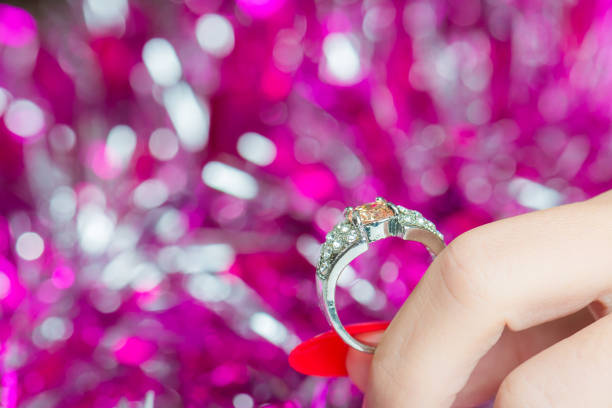 Five stone diamond,white gold ring in red box on the wooden surface with red dry roses.Conceptual image