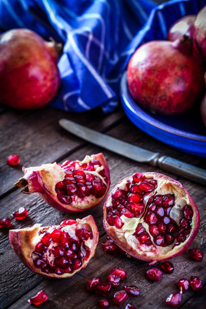 istock Fresh organic pomegranates on rustic wooden table 881515972