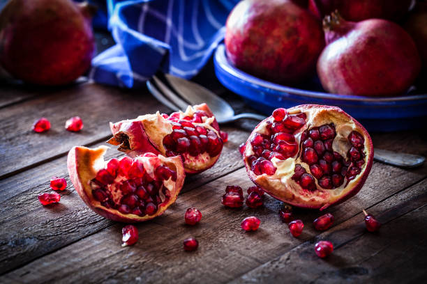 istock Fresh organic pomegranates on rustic wooden table 881516016