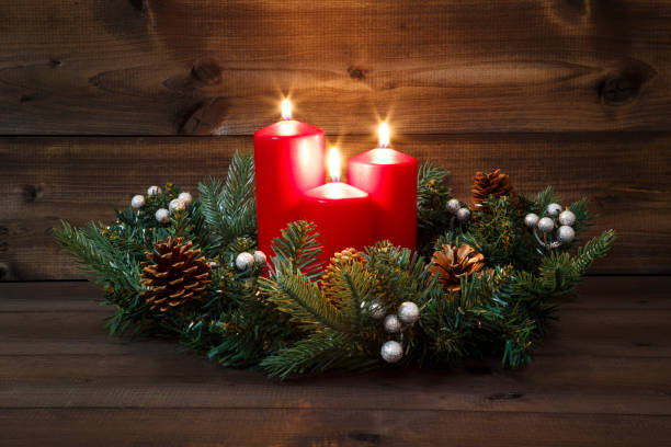 istock Third Advent - Decorated Advent wreath with three red burning candles on a wooden background 881529526