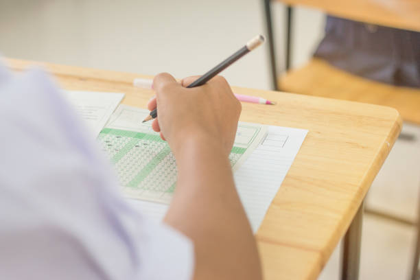 fotografii de stoc, fotografii și imagini scutite de redevențe cu elevii de concentrare exploatație creioane în mână a face mai multe opțiuni de teste de testare examene răspunde la exerciții de foi în școală, teste este evaluarea conceptului destinat să măsoare aptitudinile de cunoștințe de calificare - sală de examen