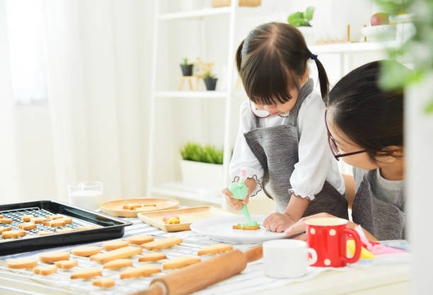 istock Asian Kid and young mother decorating cookie. 881572314