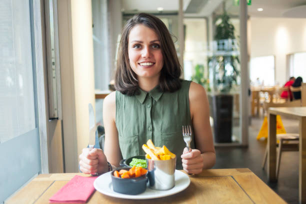 istock Young woman having lunch in restaurant 881574986