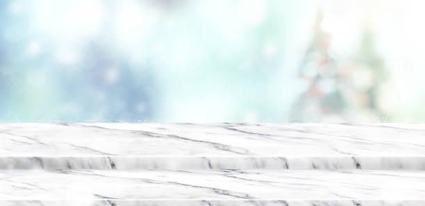istock Empty step white marble table top with abstract muted blur christmas tree and snow fall background with bokeh light,Holiday backdrop,Mock up banner for display or montage of product 881575844