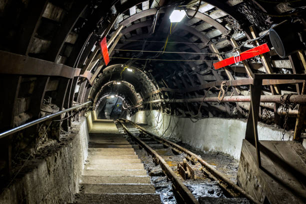 istock Coal mine underground corridor with stairs and railroad track 881576464