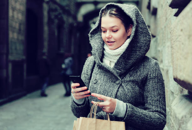istock girl using mobile phone at the street 881583354