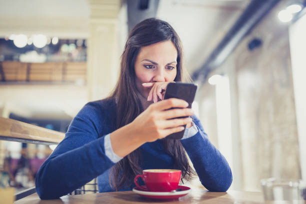 istock Single. Worried young woman using smart phone in cafe 881604070
