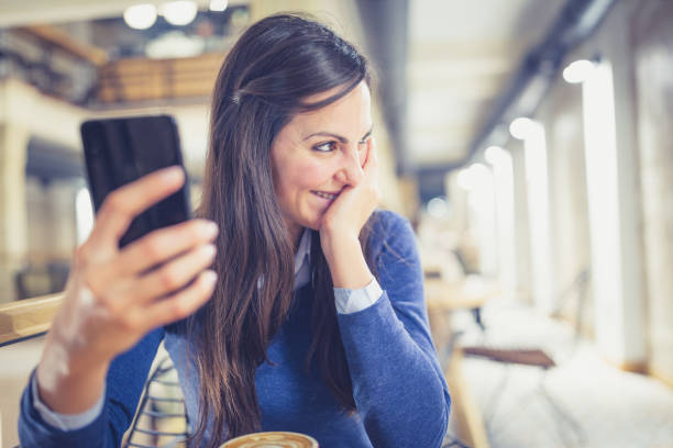 istock Single. Young woman enjoy coffee break and using smart phone in a coffee shop 881604184