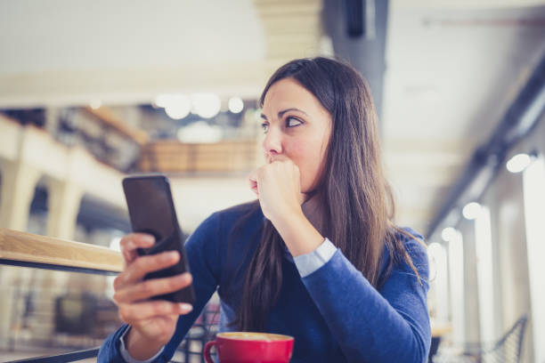 istock Single. Worried young woman using smart phone in cafe 881604198