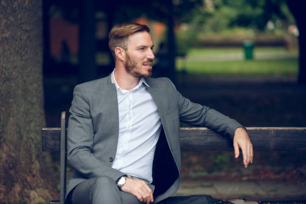 istock Young businessman sitting on park bench 881604596