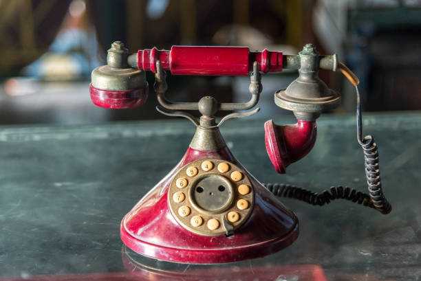 istock Old red telephone with rotary dial on glass table. 881604900