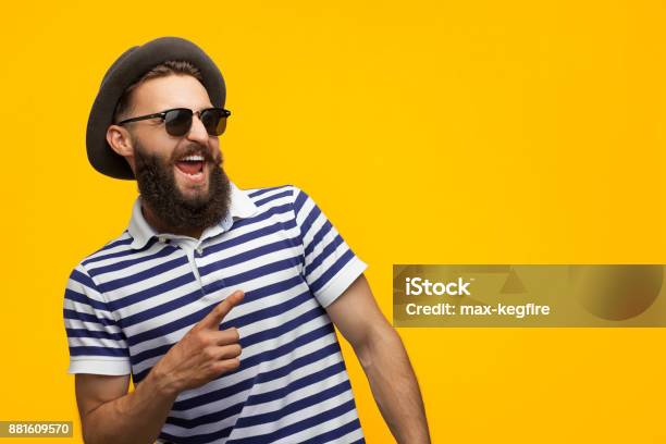 Hombre Con Estilo Hipster Apuntando Lejos Foto de stock y más banco de imágenes de Hombres - Hombres, Gafas de sol, Hípster urbano