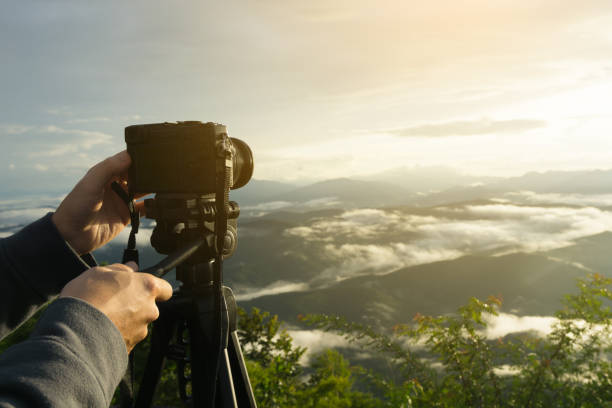 mirrorless 카메라 들고 사람 손으로 지능형 녹음 또는 th 아침에 태양 빛과 아름 다운 산의 경치를 캡처에 대 한 삼각대 위에. - fish eye lens 뉴스 사진 이미지