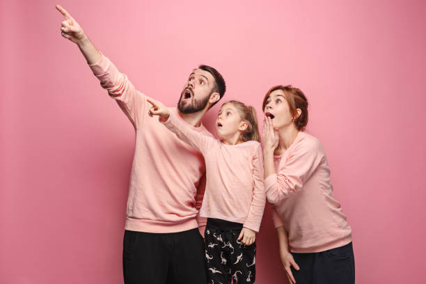 istock Surprised young family on pink 881616860