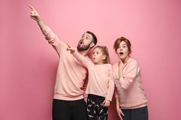 istock Surprised young family on pink 881616982