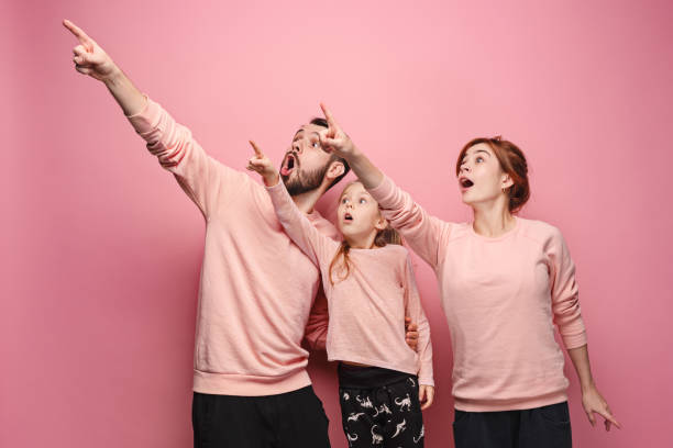 istock Surprised young family on pink 881617592