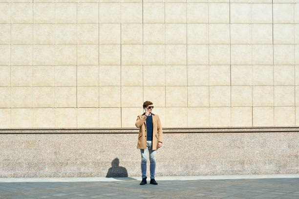 istock Modern Young Man Speaking by Phone Outdoors 881620288