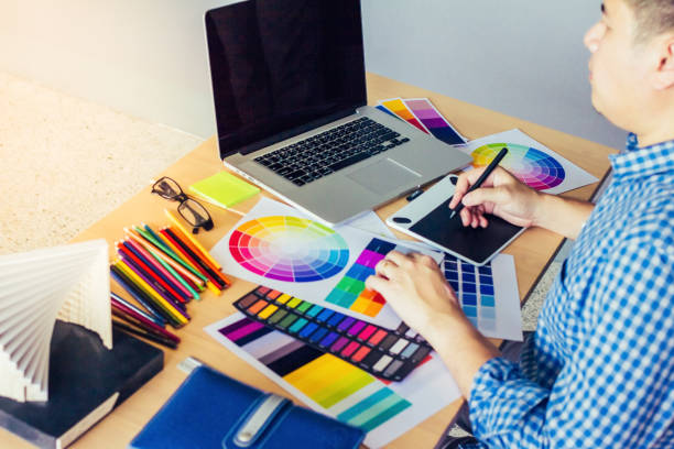 istock Designer graphic creative ,Man holding pen pointing Working on laptop in  office with sunset background,Selective focus. 881621648