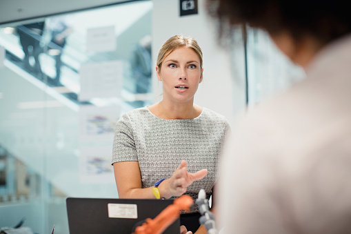 Female technician in control, talking in a meeting with her colleagues.