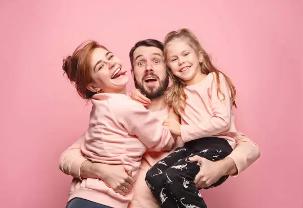 Photo of Happy young family with one little daughter posing together