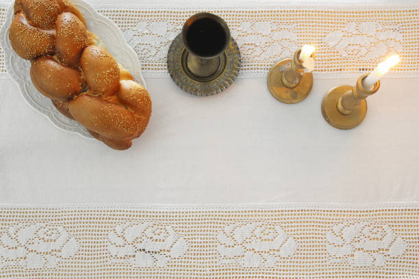 istock shabbat image. challah bread, shabbat wine and candles on the table. Top view. 881627436