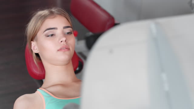 Young woman perform exercise on leg press machine