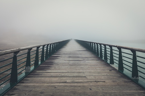 Newport, Oregon, USA - August 9, 2023.  Cars travel along the Aquina bay bridge on a very foggy summer day.