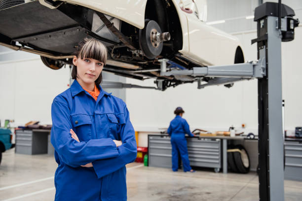 Beautiful sexy woman working to repair the car in the showroom, the style of fashion photography on the background of wheels and tires