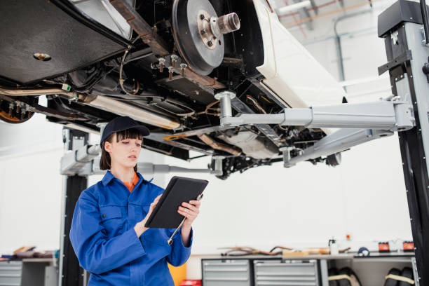 istock Female Mechanics Checking the Underside of a Car 881645522