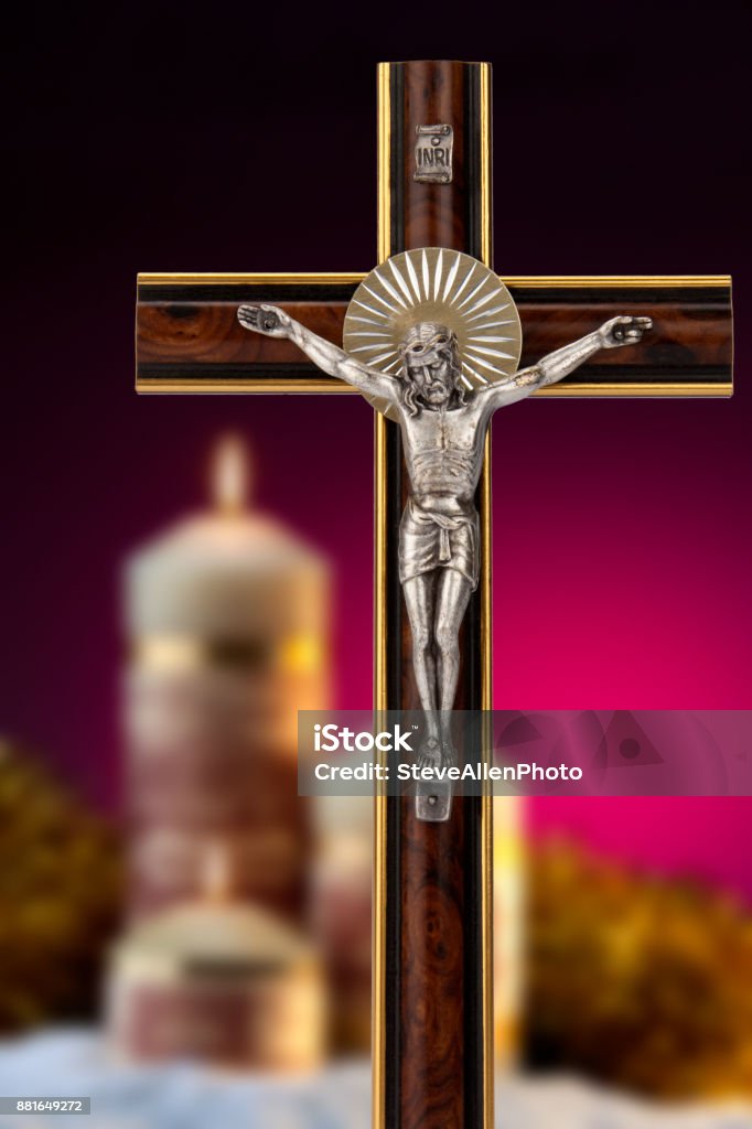 Crucifix and Church Candles Crucifix and church candles - A crucifix is an image of Jesus on the cross and is a principal religious symbol for many denominations of Christians. Burning Stock Photo