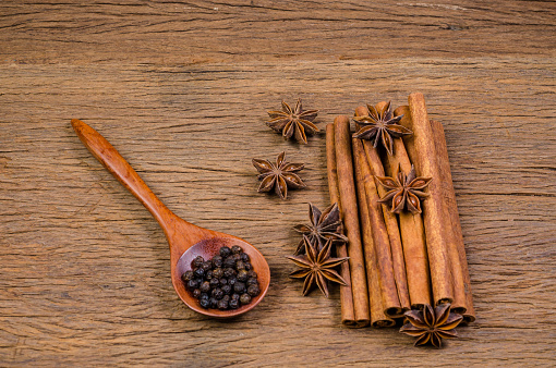 Star anise and cinnamon stick with black pepper on wooden board background,Chinese star aniseed