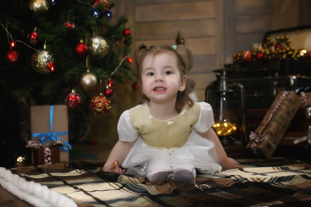 istock hild is sitting with Christmas decorations 881672528