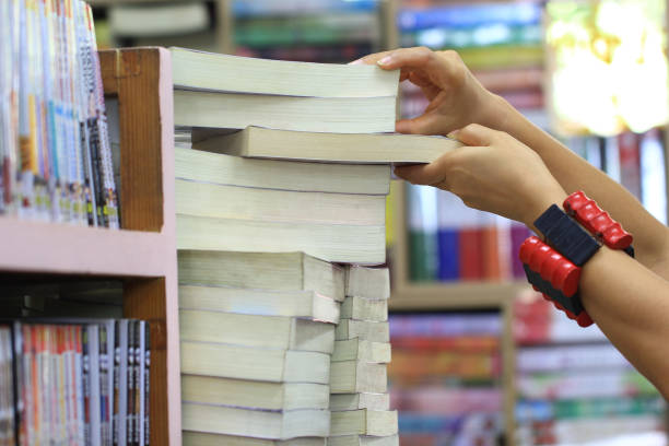 istock hand female picking book from bookshelf in the library room 881687958