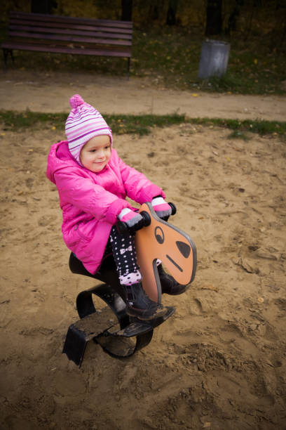 istock Little playful girl in a pink jacket 881692964