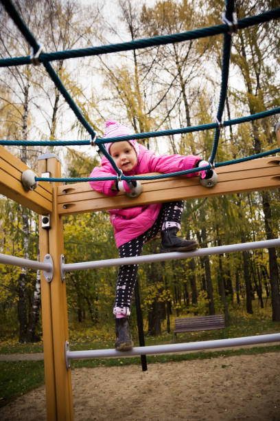istock Little playful girl in a pink jacket 881693178