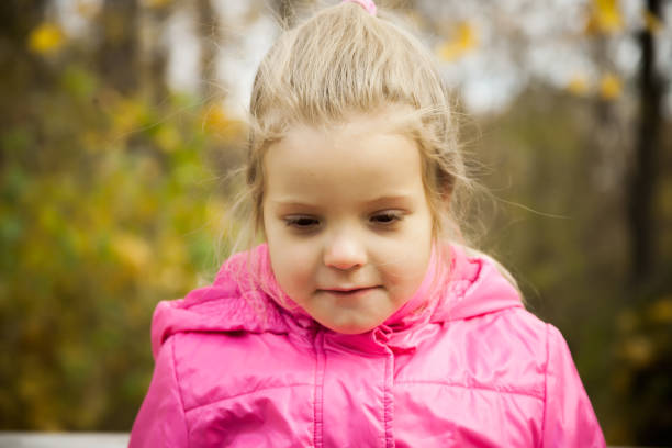 istock Little playful girl in a pink jacket 881698922