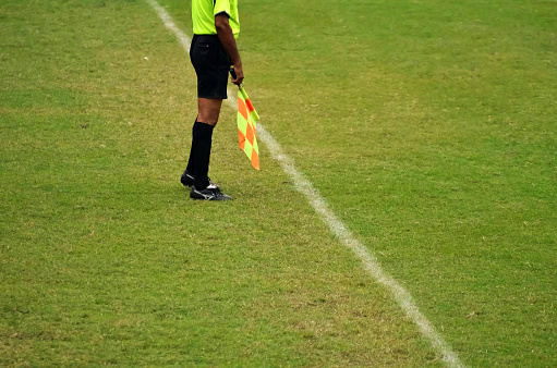 Soccer assistant referee is running along side line