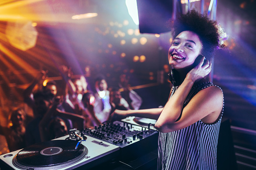 Shot of a female DJ playing music at a nightcub