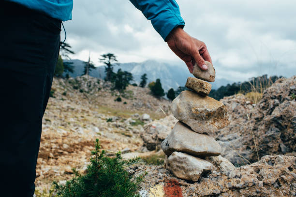 istock male hand sets a pointer out of stones - Cairn 881719236