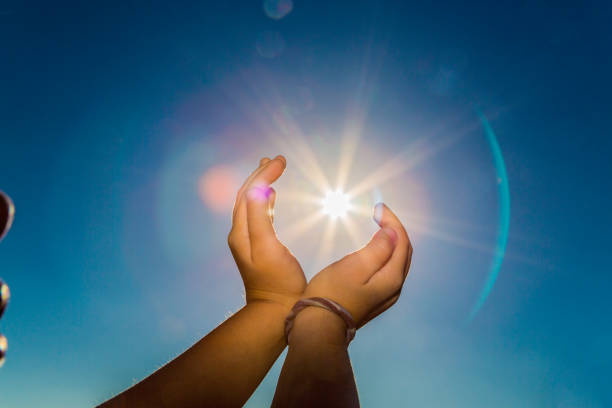 istock Two hands holding the sun on a blue sky background 881723056
