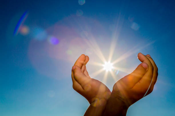 istock Two hands holding the sun on a blue sky background 881723172