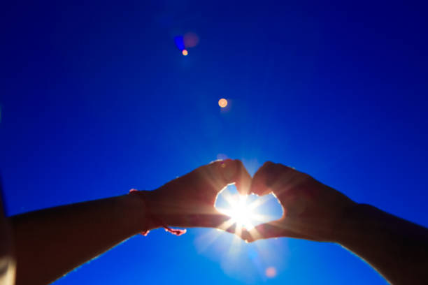 istock Two hands holding the sun on a blue sky background 881734008