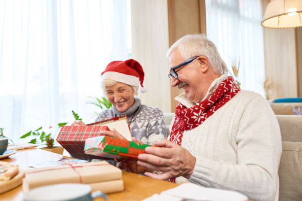 istock Happy Senior Couple Opening Christmas Presents 881744328