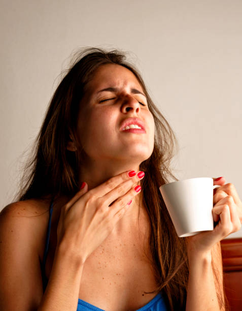 istock Young woman with sore throat and tea cup 881744556